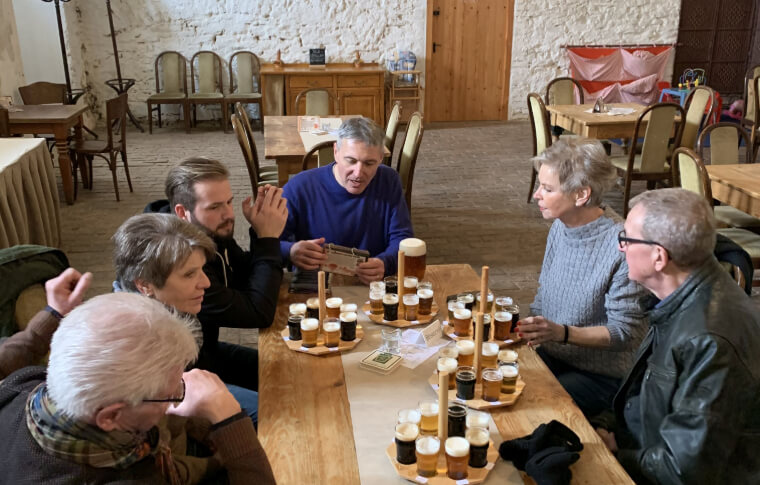 group of people sitting at table with paddles of beers