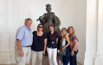 Visitors pose in front of sculpture.