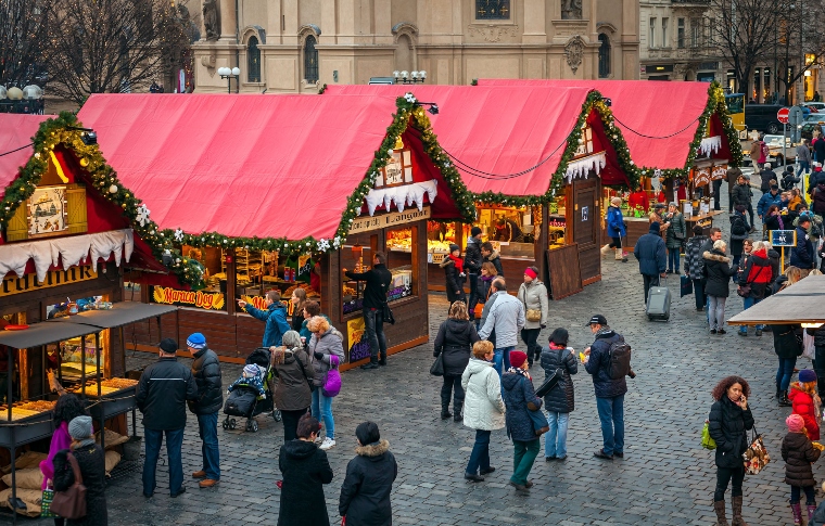 PRAGUE, CZECH REPUBLIC - DECEMBER 11, 2015: Wooden stalls offering souvenirs and traditional food during Christmas market taking place each year on December in Old Town Square (aka Staromestske Namesti).