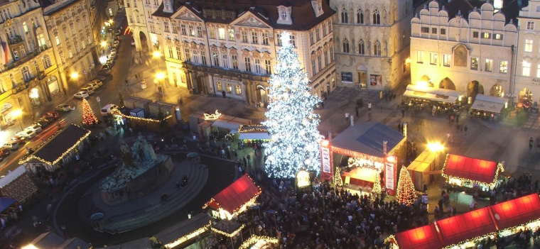 lit up christmas tree in the middle of a crowded town square in Prague, Czech Republic