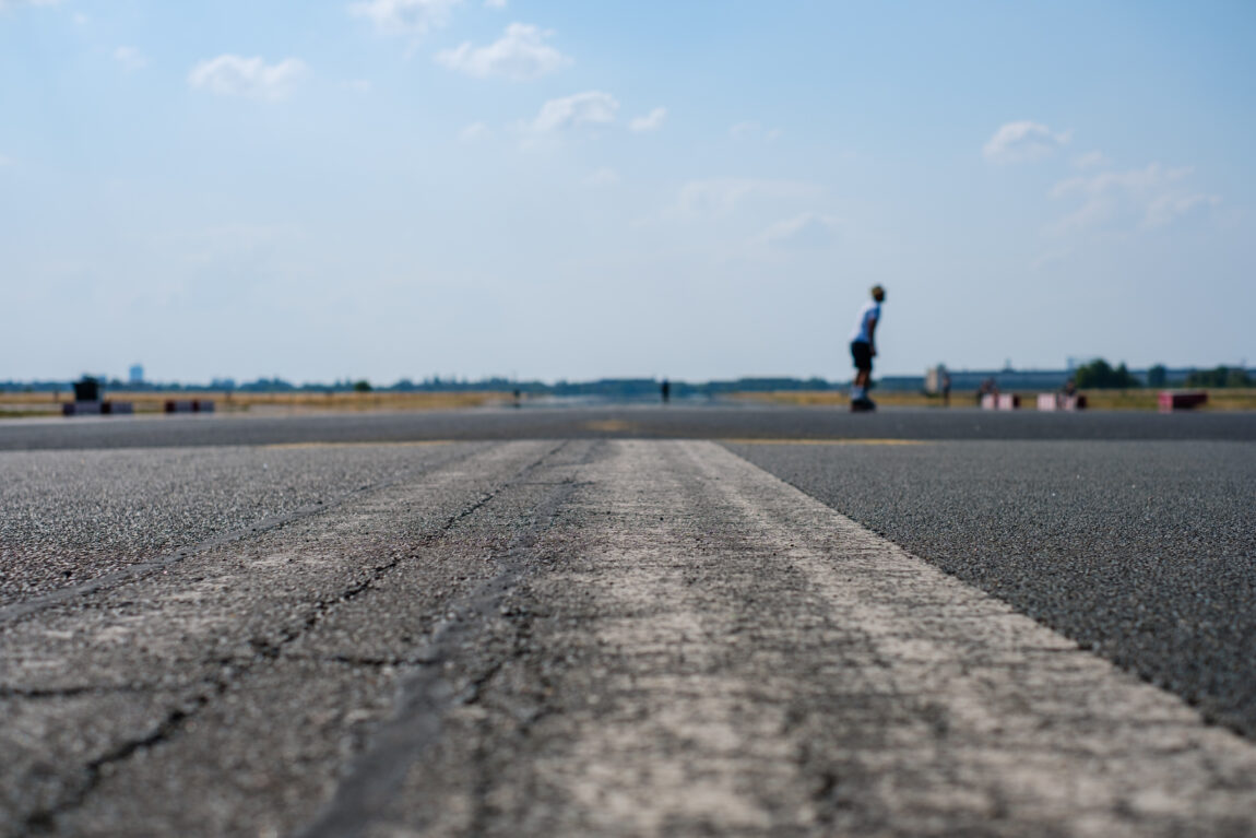 skater on empty asphalt road / runway at former airport Berlin Tempelhof on a bright sunny day