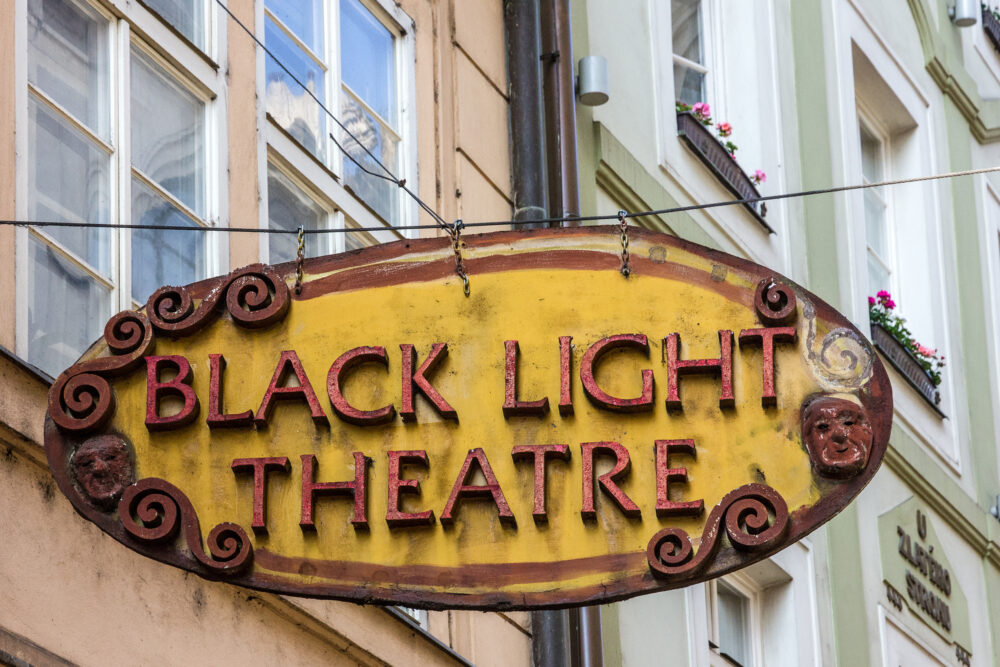 Prague Black Light Theatre sign: oval yellow sign with red capital letters