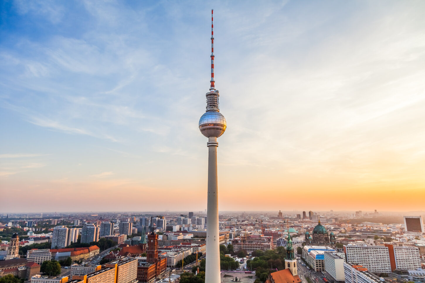 View of Berlin TV tower on Alexanderplatz, Berlin, Germany, from above the rooftops, with an orange sunset in the background
