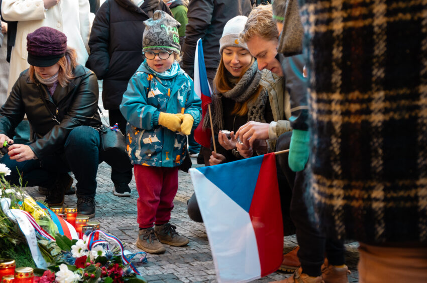 Prague, Czech Republic November 17, 2023: A young family lighting candles at the November 17th 1989 memorial plaque on Narodni trida