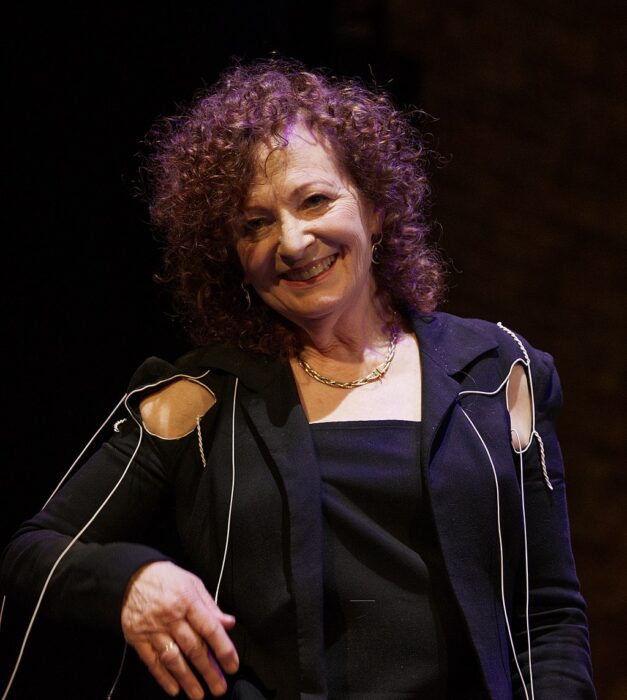 Nan Goldin in Berlin, 2023 - an older woman with curly hair smiling in a black dress