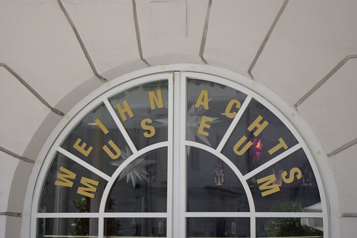 Window of Salzburg's Christmas musem, with the name in large bock letters and Christmas star decorations visible