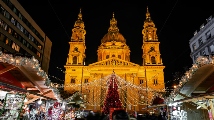 Christmas market on Vorosmarty square, Budapest, before Saint Stephen basilica wit bright evening lights