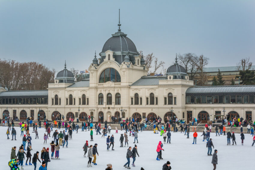 People ice skating in Budapest City Park on a sunny winter day