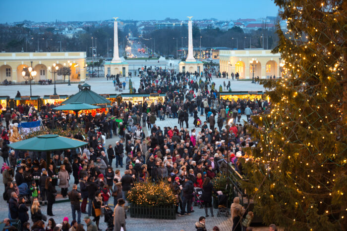 A large crowd of people gathering at the most famous Austrian Christkindlmarkt in Schoenbrunn, Vienna, Austria.