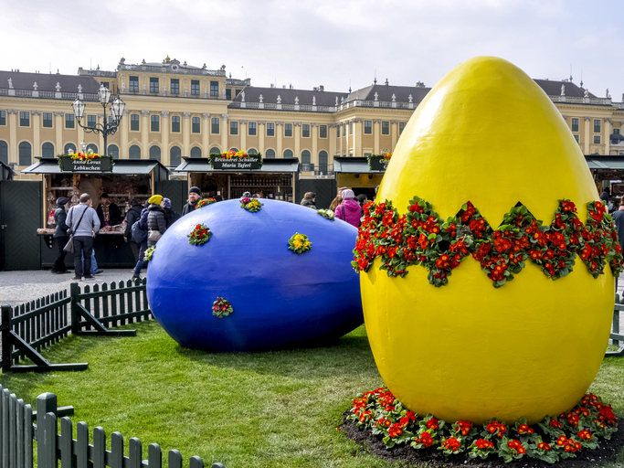 Giant blue and yellow Easter eggs on the lawn of Schonbrunn Palace, Vienna, with the palace in the background