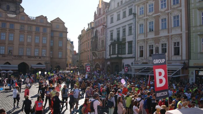 a crowd of people running the Prague Marathon in Old Town Square, Prague