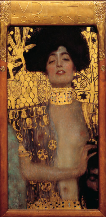 The painting Judith by Gustav Klimt - a woman with dark hair wearing a large gold necklace around her neck, with gold motifs around her.