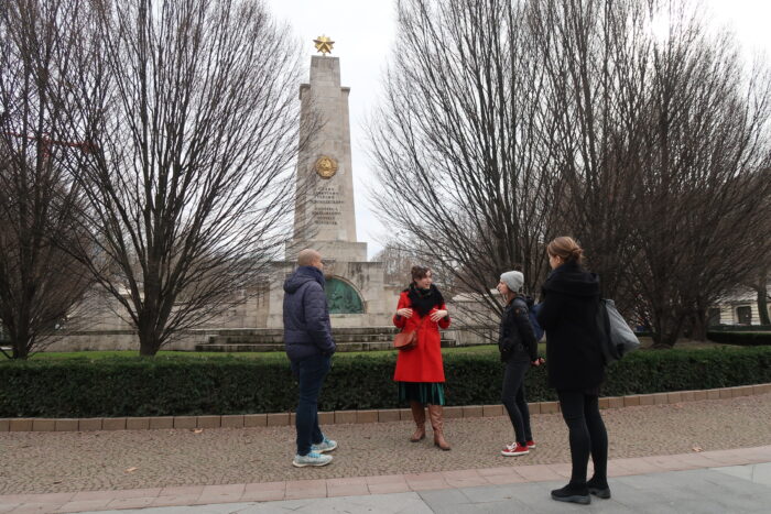 A group of people standing in front of th Soviet war Memorial at Liberty Square in Budapest, Hungary, on a cloudy winter day