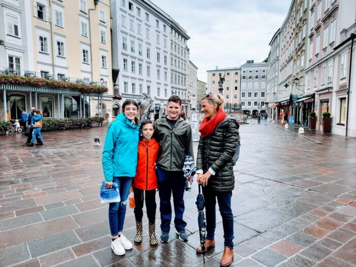 A group of people posing for a piture in the middle of a square in Salzburg, Austria