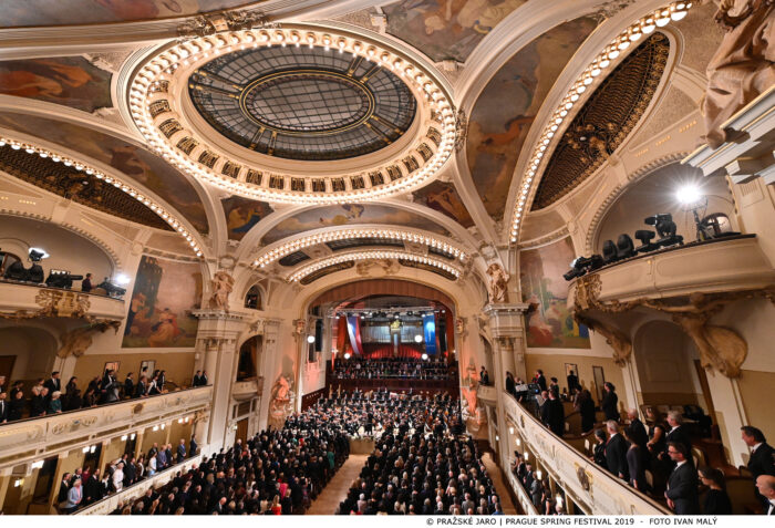 Inside the Municipal House concert hall in Prague, with musicians on stage performing in before a full audience