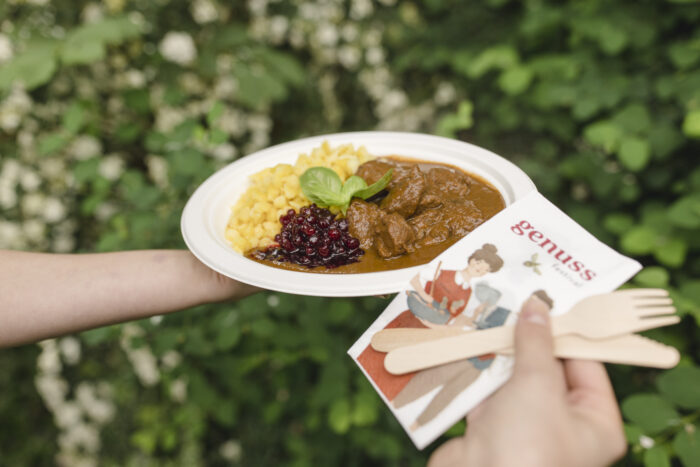 A delicious dish of meat and gravy, with fork, knife and napkin