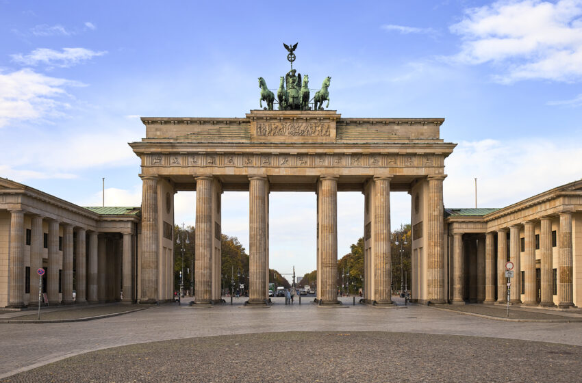 The iconic Brandenburg gate with a bright blue sky and white clouds in the background