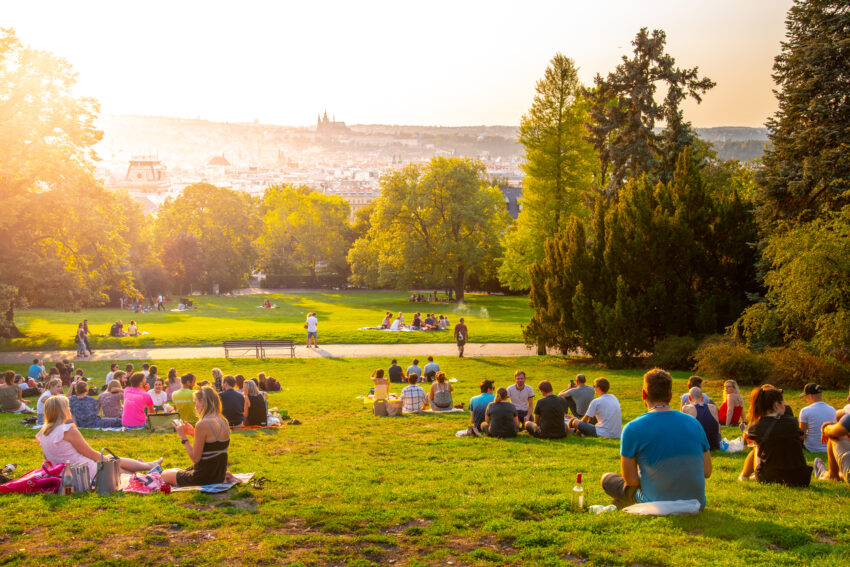 Sunset in Rieger Gardens, Riegrovy sady, in Prague. Many people sitting on the grass and enjoying sunny summer evening and lookout of Prague historical city centre. Czech Republic.